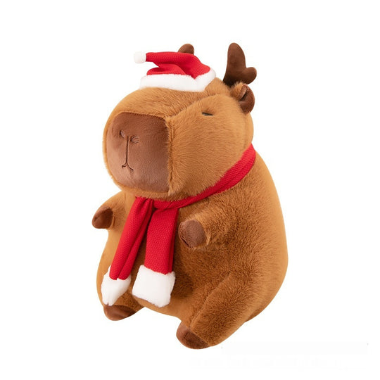 A festive capybara sitting on a table. Christmas Plushie, Capybara Plushie, Squishmallow.